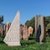 An outdoor garden with a collection of tall stone sculptures of various shapes